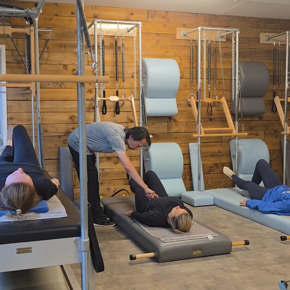 A teacher guiding clients through a mat class in the Haslemere studio