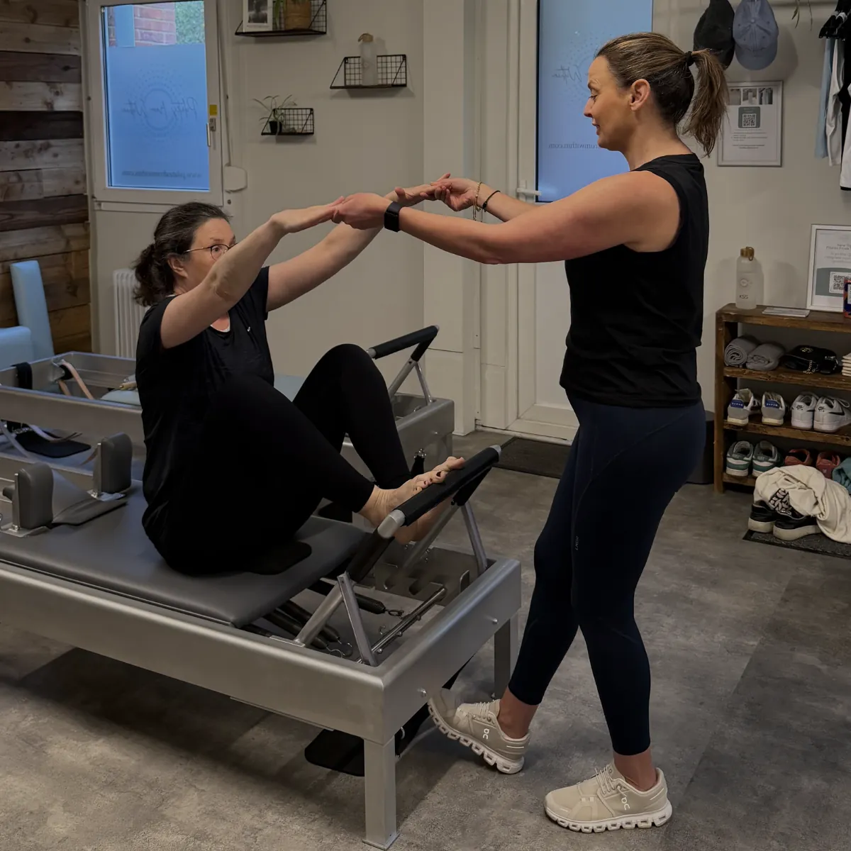 A teacher guiding a client on the Reformer at Pilates From Within, Haslemere